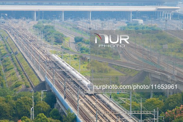 A bullet train runs near Nanjing South Railway Station in Nanjing, China, on October 10, 2024. 