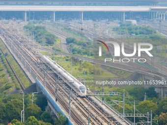 A bullet train runs near Nanjing South Railway Station in Nanjing, China, on October 10, 2024. (