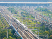 A bullet train runs near Nanjing South Railway Station in Nanjing, China, on October 10, 2024. (