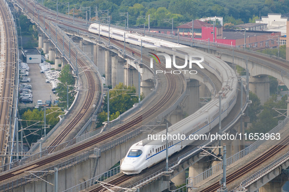 A bullet train runs near Nanjing South Railway Station in Nanjing, China, on October 10, 2024. 