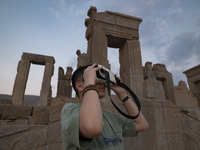 An Iranian young boy uses VR glasses while visiting the Persepolis historical site near the city of Shiraz in Fars province, about 932 km (5...