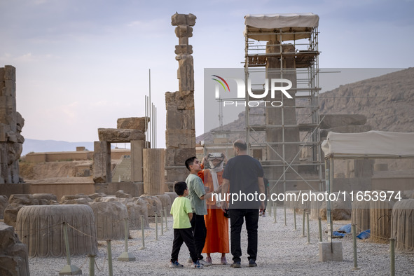 An Iranian woman uses VR glasses while visiting the Persepolis historical site near the city of Shiraz in Fars province, about 932 km (579 m...