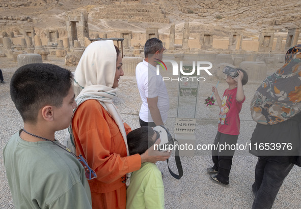 Iranian young boys use VR glasses while visiting the Persepolis historical site near the city of Shiraz in Fars province, about 932 km (579...