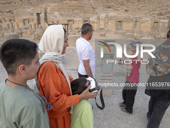 Iranian young boys use VR glasses while visiting the Persepolis historical site near the city of Shiraz in Fars province, about 932 km (579...