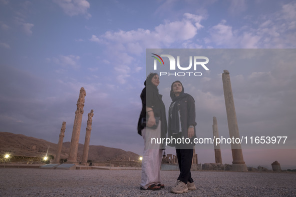 Two young Iranian women pose for a photograph while visiting the Persepolis historical site near Shiraz, Iran, on October 9, 2024.  