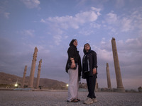 Two young Iranian women pose for a photograph while visiting the Persepolis historical site near Shiraz, Iran, on October 9, 2024.  (