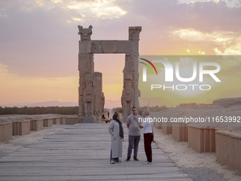 An Iranian guide speaks with an Iranian couple visiting the Persepolis historical site near the city of Shiraz in Fars province, about 932 k...