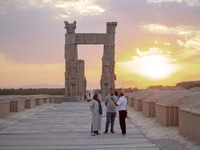 An Iranian guide speaks with an Iranian couple visiting the Persepolis historical site near the city of Shiraz in Fars province, about 932 k...