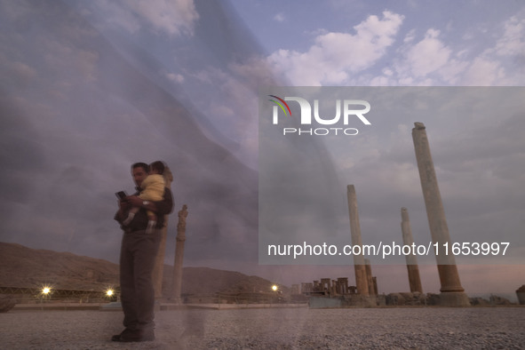 An Iranian man carries his child and visits the Persepolis historical site near the city of Shiraz in Fars province, about 932 km (579 miles...