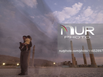 An Iranian man carries his child and visits the Persepolis historical site near the city of Shiraz in Fars province, about 932 km (579 miles...