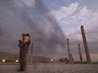 An Iranian man carries his child and visits the Persepolis historical site near the city of Shiraz in Fars province, about 932 km (579 miles...