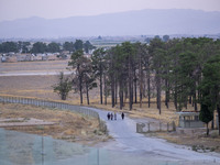 Iranian women walk along a road while visiting the Persepolis historical site near the city of Shiraz in Fars province, about 932 km (579 mi...