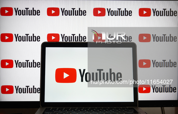 YouTube logos displayed on a screen and a laptop are seen in L’Aquila, Italy, on October 9th, 2024. 