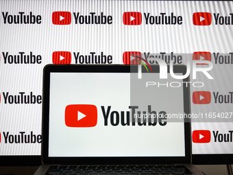 YouTube logos displayed on a screen and a laptop are seen in L’Aquila, Italy, on October 9th, 2024. (