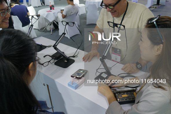 Visitors view AI glasses at the International Consumer Electronics Show in Shanghai, China, on October 10, 2024. 