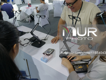 Visitors view AI glasses at the International Consumer Electronics Show in Shanghai, China, on October 10, 2024. (