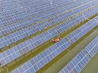 A worker checks photovoltaic equipment at a fishery-solar hybrid base in Suqian, China, on October 10, 2024. (