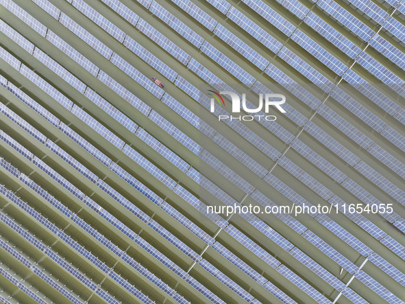 A worker checks photovoltaic equipment at a fishery-solar hybrid base in Suqian, China, on October 10, 2024. 