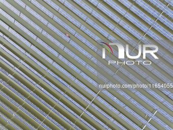 A worker checks photovoltaic equipment at a fishery-solar hybrid base in Suqian, China, on October 10, 2024. (