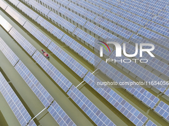 A worker checks photovoltaic equipment at a fishery-solar hybrid base in Suqian, China, on October 10, 2024. (