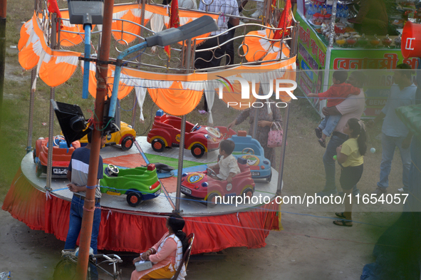 Children enjoy a ride at a fair set up near Durga Puja Pandal in Siliguri, India, on October 10, 2024. 