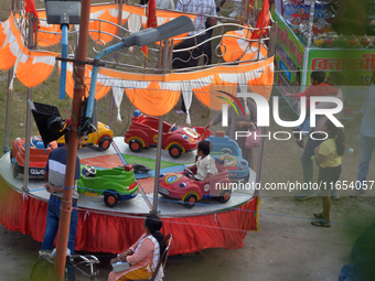 Children enjoy a ride at a fair set up near Durga Puja Pandal in Siliguri, India, on October 10, 2024. (