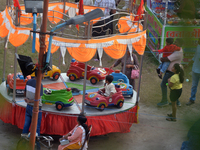 Children enjoy a ride at a fair set up near Durga Puja Pandal in Siliguri, India, on October 10, 2024. (