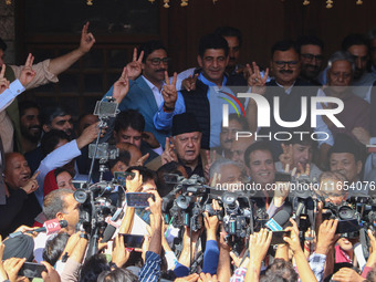 Former chief minister of Jammu and Kashmir and Jammu and Kashmir National Conference (JKNC) party president Farooq Abdullah (Center) stands...