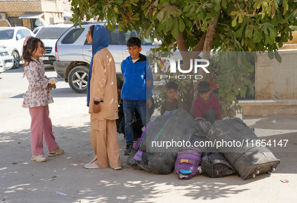 Syrian refugees return to their homeland through the Aoun Al-Dadat crossing in northern Manbij after traveling from Lebanon to opposition-he...