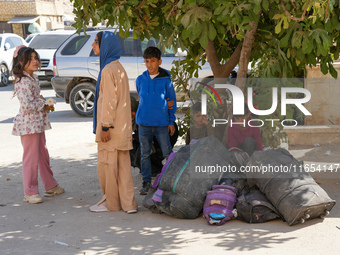 Syrian refugees return to their homeland through the Aoun Al-Dadat crossing in northern Manbij after traveling from Lebanon to opposition-he...