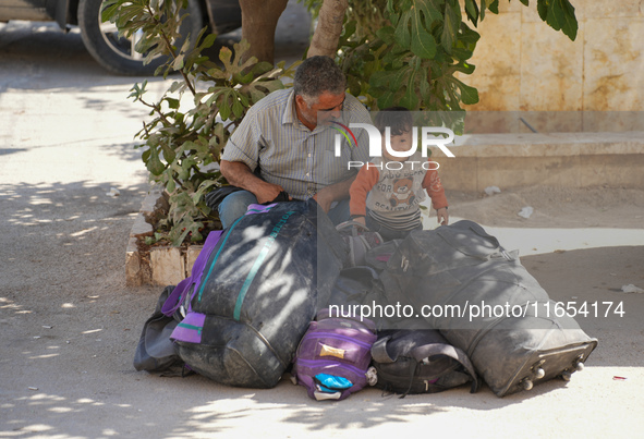 Syrian refugees return to their homeland through the Aoun Al-Dadat crossing in northern Manbij after traveling from Lebanon to opposition-he...