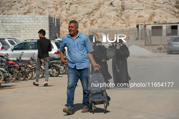 Syrian refugees return to their homeland through the Aoun Al-Dadat crossing in northern Manbij after traveling from Lebanon to opposition-he...