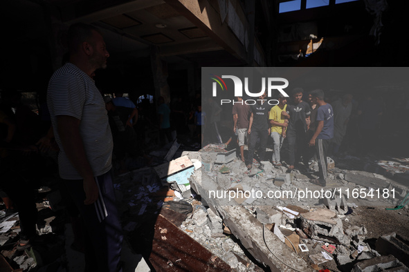 Palestinians inspect a school that the Israeli occupation army attacks in Deir al-Balah, Gaza, on October 10, 2024. The Israeli army attacks...