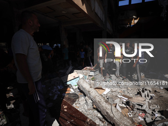 Palestinians inspect a school that the Israeli occupation army attacks in Deir al-Balah, Gaza, on October 10, 2024. The Israeli army attacks...