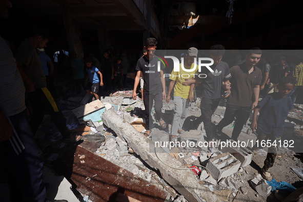 Palestinians inspect a school that the Israeli occupation army attacks in Deir al-Balah, Gaza, on October 10, 2024. The Israeli army attacks...