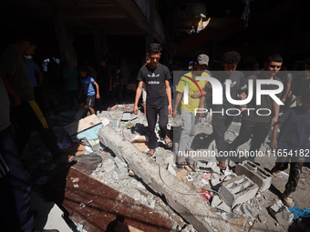 Palestinians inspect a school that the Israeli occupation army attacks in Deir al-Balah, Gaza, on October 10, 2024. The Israeli army attacks...