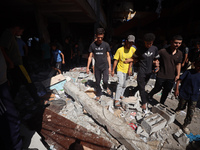 Palestinians inspect a school that the Israeli occupation army attacks in Deir al-Balah, Gaza, on October 10, 2024. The Israeli army attacks...