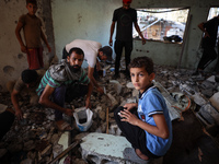 Palestinians inspect a school that the Israeli occupation army attacks in Deir al-Balah, Gaza, on October 10, 2024. The Israeli army attacks...