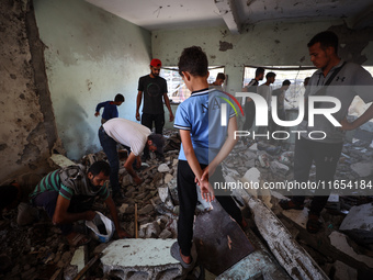 Palestinians inspect a school that the Israeli occupation army attacks in Deir al-Balah, Gaza, on October 10, 2024. The Israeli army attacks...