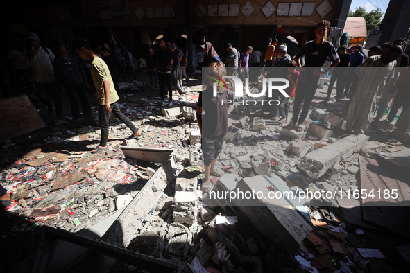 Palestinians inspect a school that the Israeli occupation army attacks in Deir al-Balah, Gaza, on October 10, 2024. The Israeli army attacks...