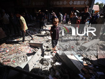 Palestinians inspect a school that the Israeli occupation army attacks in Deir al-Balah, Gaza, on October 10, 2024. The Israeli army attacks...