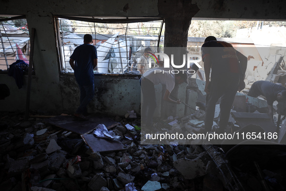 Palestinians inspect a school that the Israeli occupation army attacks in Deir al-Balah, Gaza, on October 10, 2024. The Israeli army attacks...