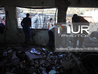 Palestinians inspect a school that the Israeli occupation army attacks in Deir al-Balah, Gaza, on October 10, 2024. The Israeli army attacks...