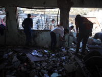 Palestinians inspect a school that the Israeli occupation army attacks in Deir al-Balah, Gaza, on October 10, 2024. The Israeli army attacks...