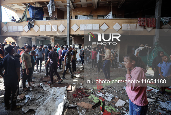 Palestinians inspect a school that the Israeli occupation army attacks in Deir al-Balah, Gaza, on October 10, 2024. The Israeli army attacks...