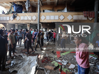 Palestinians inspect a school that the Israeli occupation army attacks in Deir al-Balah, Gaza, on October 10, 2024. The Israeli army attacks...