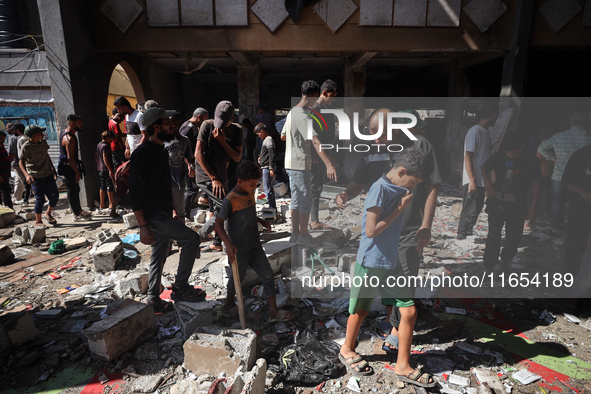 Palestinians inspect a school that the Israeli occupation army attacks in Deir al-Balah, Gaza, on October 10, 2024. The Israeli army attacks...