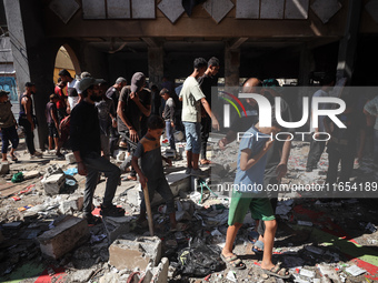 Palestinians inspect a school that the Israeli occupation army attacks in Deir al-Balah, Gaza, on October 10, 2024. The Israeli army attacks...