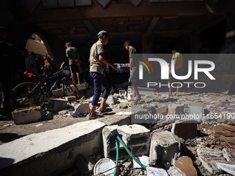 Palestinians inspect a school that the Israeli occupation army attacks in Deir al-Balah, Gaza, on October 10, 2024. The Israeli army attacks...