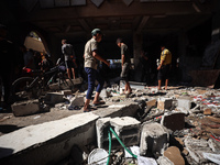 Palestinians inspect a school that the Israeli occupation army attacks in Deir al-Balah, Gaza, on October 10, 2024. The Israeli army attacks...